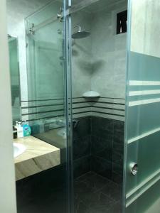 a glass shower in a bathroom with a sink at Holiday Hotel 2 in Hai Phong