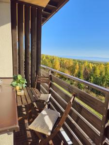 a balcony with two chairs and a table with a view at Tatranka - Vysoké Tatry in Vysoké Tatry +4 photos