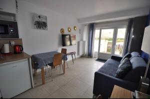 a living room with a blue couch and a table at Appartement Cambita in Montévrain