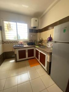 a kitchen with a white refrigerator and a tile floor at Marwan's apartment 2 in Ifrane