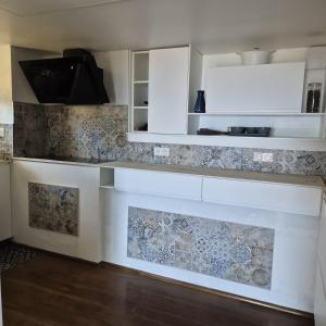 eine Küche mit weißen Schränken und Wandfliesen in der Unterkunft Bella Vista in La Vasina + 1 Foto