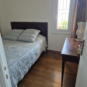 Schlafzimmer mit einem Bett mit einem Tisch und einem Fenster in der Unterkunft Bella Vista in La Vasina