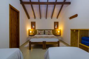 パラチにあるPousada Vila do Portoのベッドが2つあり、天井が木製の寝室