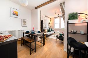 a kitchen and living room with a table and chairs at 1BR Stylish Flat by HostaraHomes, Near Liverpool Street, Prime London Location, Sleeps up to 4 in London