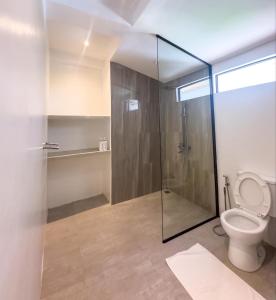 a bathroom with a toilet and a glass shower at Orchids Villa Elnido in El Nido