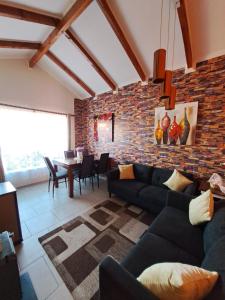 a living room with a couch and a brick wall at Casa aislada 1 piso Peñaflor-Malloco in Peñaflor