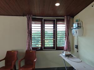 a room with two chairs and a window at Mandagadde homestay sringeri in Sringeri