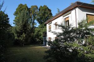 a white house with trees in front of it at Appartamento Le Magnolie in Mestre
