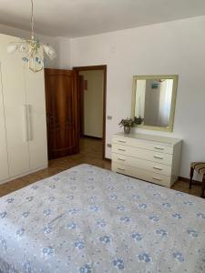 a bedroom with a bed and a dresser and a mirror at HouseMi in Magliano di Tenna