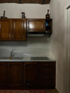 una cucina con armadi in legno e lavandino di Rabat home a Tursi