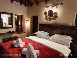 a bedroom with a large bed with towels on it at Litheon House in Synikia Mesi Trikalon