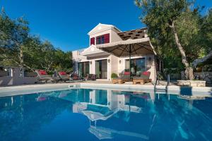 a house with a swimming pool in front of a house at Triena Villas by PaxosRetreats in Gaios