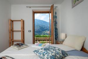 a room with two beds and a window with a view at B&B Casa Nadia in Tesero