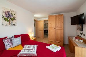 a living room with a red couch and a flat screen tv at B&B Casa Nadia in Tesero