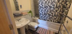 Un baño con lavabo, inodoro y ducha. en Double room&Private bath near the Square Mile, en Londres
