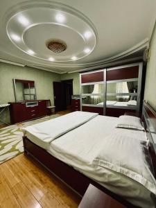 a bedroom with a large bed and a ceiling at CHEKHOV APARTMENT in Tashkent