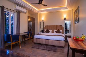 een hotelkamer met een bed, een tafel en stoelen bij Hotel Lords Valley Rishikesh in Rishīkesh