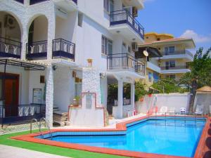 a hotel with a swimming pool in front of a building at Villa Fortin Pension in Kuşadası