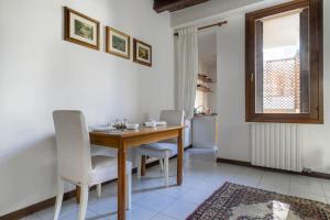 a dining room with a wooden table and white chairs at i-HOMES JuniorSuite Centro Padova in Padova