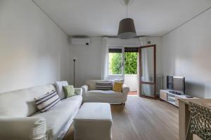a living room with a white couch and a tv at i-HOMES Family Comfort Padova in Padova