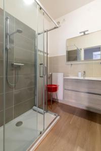 a bathroom with a glass shower and a red stool at i-HOMES Family Comfort Padova in Padova +20 photos