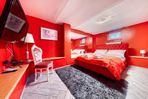 een slaapkamer met rode muren, een bed en een bureau bij Apartamenty Firfas 2 in Bydgoszcz