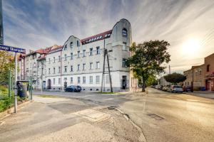 een groot wit gebouw aan de kant van een straat bij Apartamenty Firfas 2 in Bydgoszcz