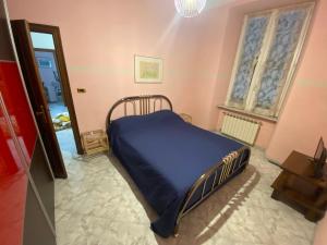 a bedroom with a bed with a blue blanket at Bed'n Fast Savona in Savona