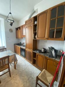 a kitchen with wooden cabinets and a table at Bed'n Fast Savona in Savona