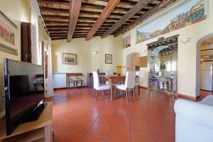 a living room with a table and chairs and a television at Classic roman home next to Popolo Square in Rome