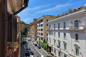a view of a city street with parked cars and buildings at Classic roman home next to Popolo Square in Rome