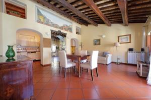 a living room with a wooden table and white chairs at Classic roman home next to Popolo Square in Rome