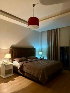 a bedroom with a large bed and a red lamp at Sea Breez The Grant Hotel Apartment in Bilgah