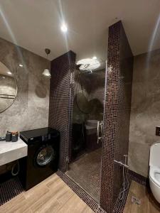 a bathroom with a shower with a toilet and a sink at Sea Breez The Grant Hotel Apartment in Bilgah