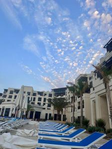 a row of blue lounge chairs on a beach at Sea Breez The Grant Hotel Apartment in Bilgah