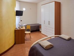 a bedroom with a bed and a cabinet and a desk at BnB Anna e Leo - Casa di Leo in Pietra Montecorvino