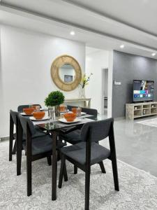 a dining table and chairs in a living room at Azure 3bdrm beachfront at jumeirah palm resort nyali in Bamburi