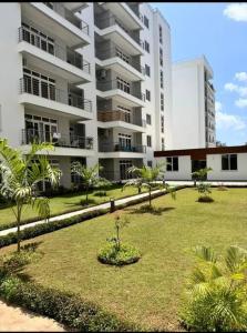 a park in front of a large apartment building at Azure 4bdrm beachfront at jumeirah palm resort nyali in Bamburi