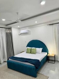 a bedroom with a large bed with a blue headboard at Azure 4bdrm beachfront at jumeirah palm resort nyali in Bamburi +17 photos