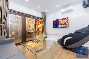 un salon avec une chaise et une table en verre dans l'établissement Cối Xoay Gió Trệt Không Lầu - 6 Phòng Ngủ - Bida - Karaoke Phòng Lạnh - Gần Biển Bãi Sau Vũng Tàu, à Vung Tau