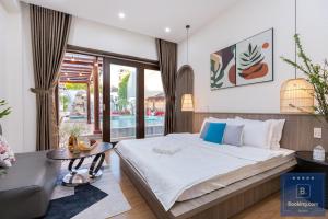 une chambre avec un grand lit et une table dans l'établissement Cối Xoay Gió Trệt Không Lầu - 6 Phòng Ngủ - Bida - Karaoke Phòng Lạnh - Gần Biển Bãi Sau Vũng Tàu, à Vung Tau