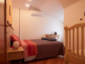 a small bedroom with a bed and a crib at BnB Anna e Leo - Casa di Leo in Pietra Montecorvino +26 photos