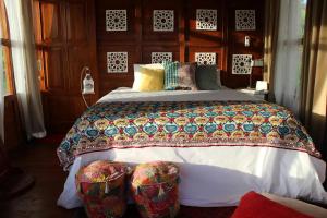 a bedroom with a large bed with two chairs at Berawagaya Bungalows in Dalung