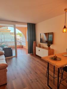 Una sala de estar con una mesa y un televisor. en Ocean View Luxury Big Terrace 1 Bedroom, en Adeje