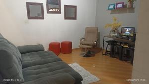 a living room with a couch and a desk at CASA sobrado edícula aconchegante in São Paulo