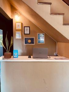 a laptop computer sitting on a counter under a staircase at Adios Amigos Hostel in Arraial d'Ajuda