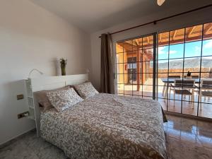 a bedroom with a bed and a view of a patio at Casa Tortuga in Tarajalejo