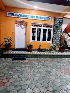 an orange building with a sign that reads expect adventure trips and explanation at Buddha Home Nepal in Thapathali
