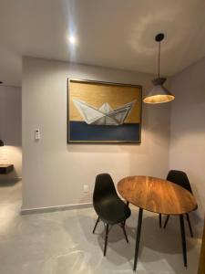 une salle à manger avec une table et un bateau en papier au mur dans l'établissement Nayfer Suites, à Playa del Carmen