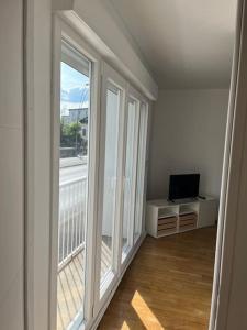 una stanza vuota con due grandi finestre e una televisione di T2 - Quartier Mézières - 1 chambre -1 terrasse a Charleville-Mézières